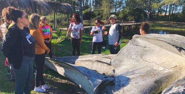Pessoas observando ossada de baleia jubarte