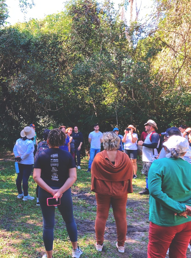 Pessoas reunidas em circulo em aula sobre eduação ambiental