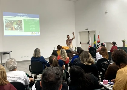Sala de aula com alunos sendados assistindo à aula