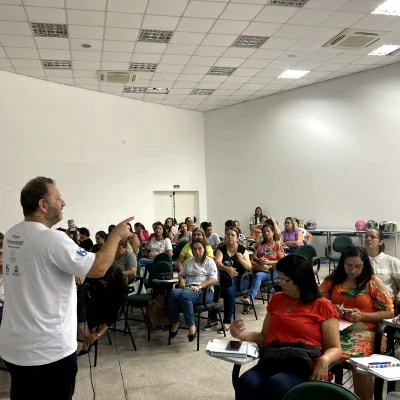 Professor, em pé, falando aos alunos, sentados.