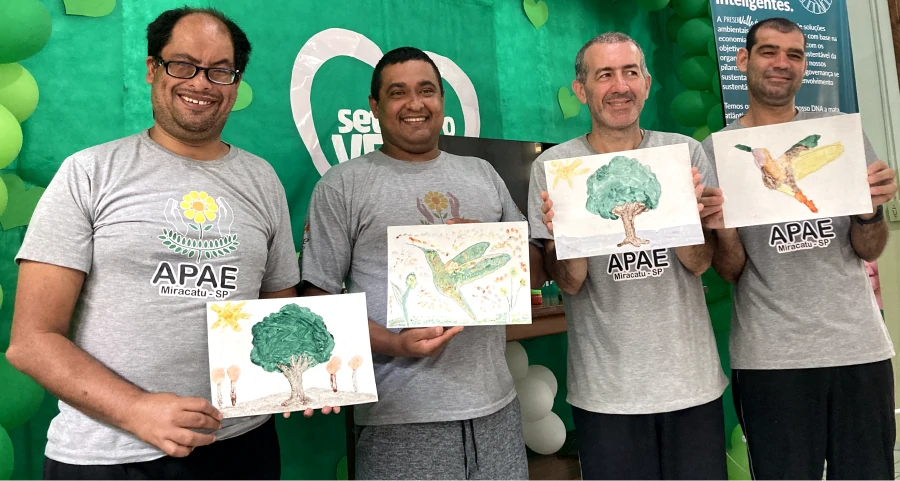 Foto de diversos alunos exibindo suas pinturas